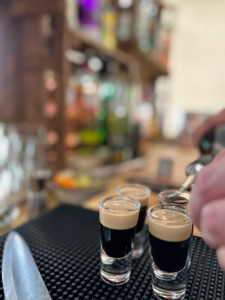 Small cocktail glasses being filled at the bar