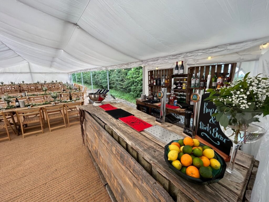 Raise the Bar mobile bar beside dining tables in a wedding marquee